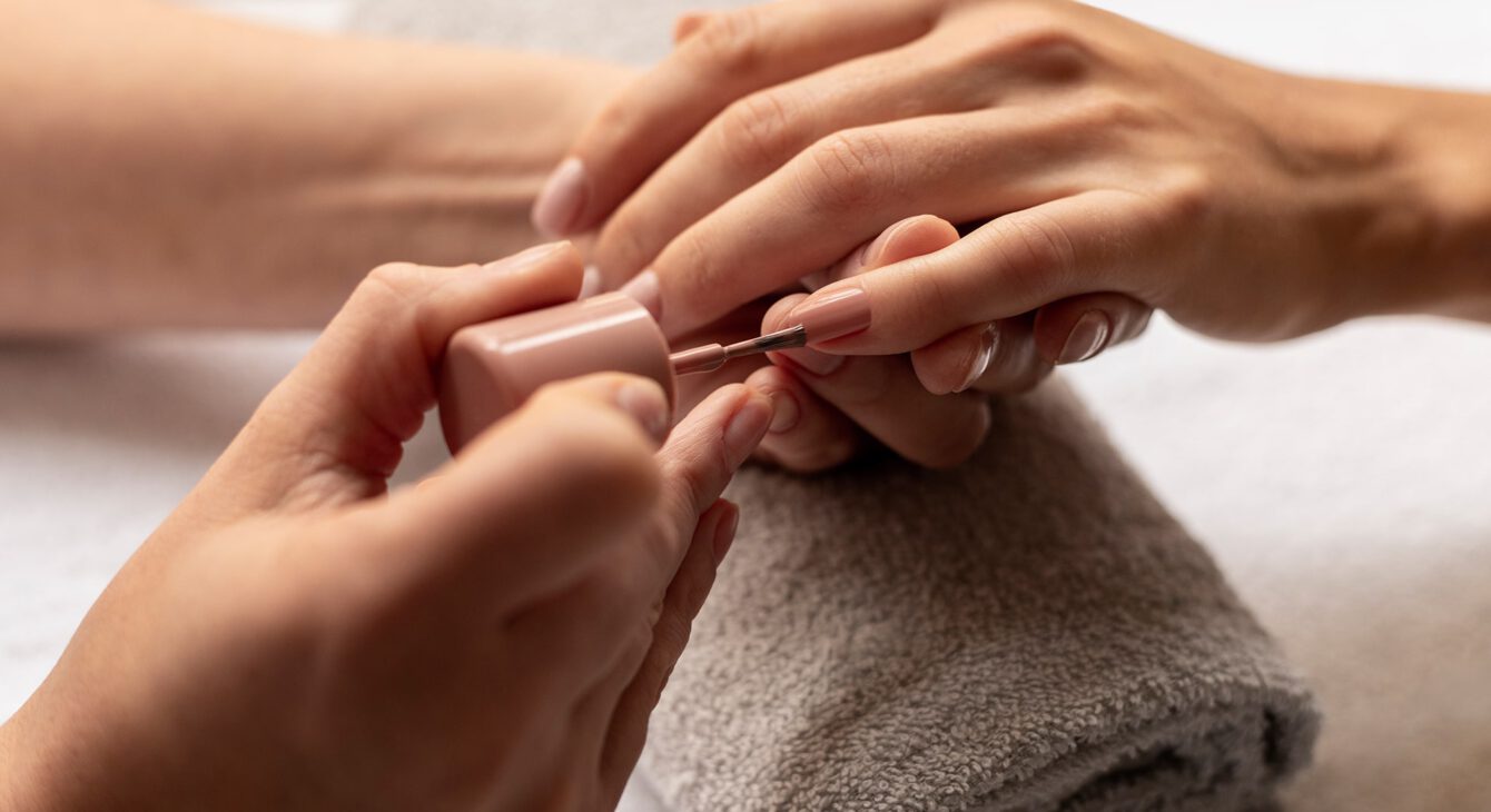 close-up-manicurist-applying-nail-polish