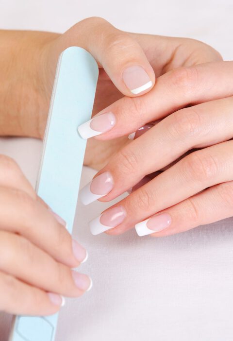 manicurist-doing-polishing-female-fingernails-with-french-manicure